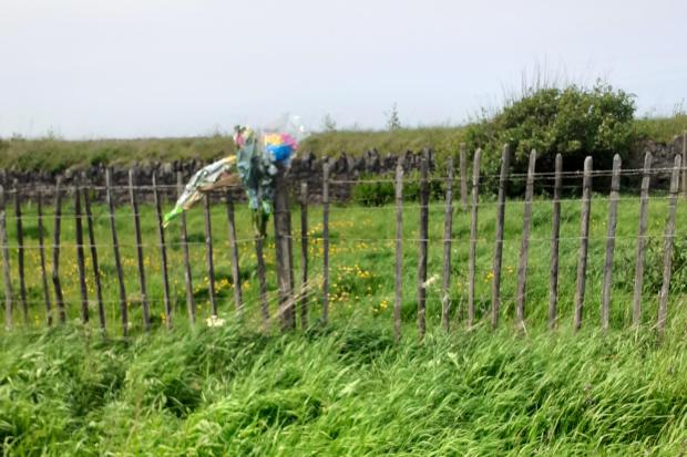 SCENE: Floral tributes left at the scene of the tragic incident, on the A595 in Flimby.